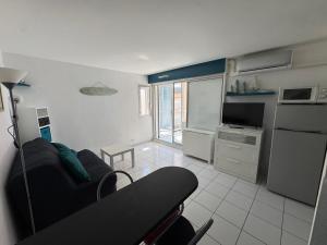 a living room with a couch and a kitchen at Studio - résidence avec piscine in Cap d'Agde