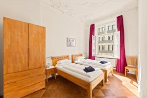 2 camas en una habitación con cortinas rojas en Downtown Landmark near Checkpoint Charlie - fully preserved, en Berlín