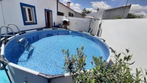 a large blue swimming pool sitting next to a white building at Não te vou esquecer Aldeia da Luz! in Luz