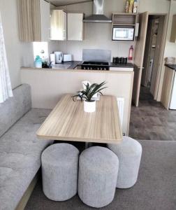 a kitchen with a table and two stools with a table at Lorna's Hideaway! in Selsey