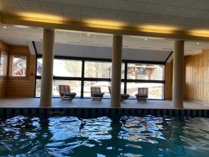 basen z krzesłami i basenem z wodą w obiekcie Pied des Pistes, 2 pièces, 6pers, Piscine et Sauna w mieście Risoul