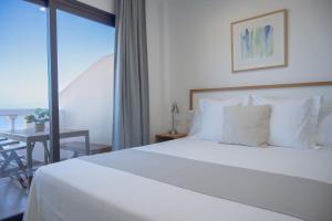 a bedroom with a large white bed and a balcony at ABLANCAS - La Restinga in La Restinga