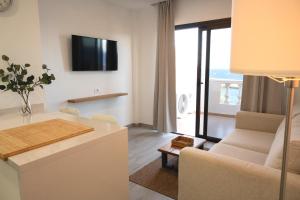 a living room with a couch and a tv on the wall at ABLANCAS - La Restinga in La Restinga