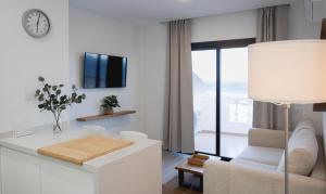 a white living room with a table and a clock at ABLANCAS - La Restinga in La Restinga