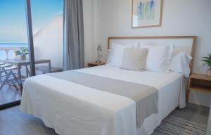 a bedroom with a large white bed and a table at ABLANCAS - La Restinga in La Restinga