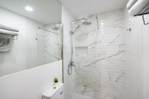 a white bathroom with a shower and a toilet at ABLANCAS - La Restinga in La Restinga