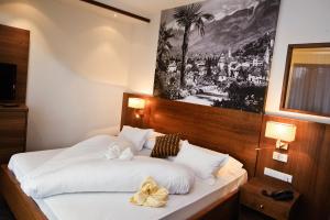 a bed in a room with a picture on the wall at Hotel Anatol in Merano