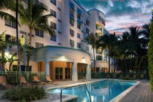 デイニア・ビーチにあるCourtyard by Marriott Fort Lauderdale Airport & Cruise Portの建物の前にプールがあるホテル