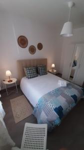 a bedroom with a large white bed and a table at Não te vou esquecer Aldeia da Luz! in Luz +21 photos