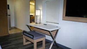 a room with a desk and a chair and a television at Waterfront Inn PHL Airport in Essington