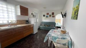 eine Küche mit einem Tisch und eine Küche mit einem Waschbecken und einem Tisch in der Unterkunft Casa Mango, con piscina y vistas al mar y volcán in El Paso