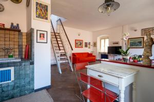 a living room with red chairs and a table and a staircase at La casa di Zedo in Lerici