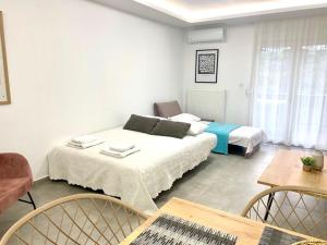 a bedroom with two beds and a table and chairs at Margarita's apartment 4 in Nea Peramos