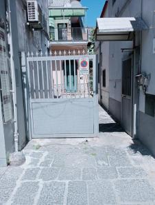 a white gate in an alley with a building at La Rosa di Pompei in Scafati