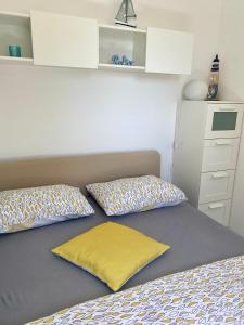a bedroom with a bed with two pillows on it at Studio Lokvica in Omišalj