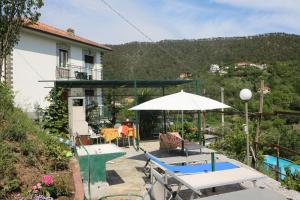 patio ze stołem i parasolem w obiekcie Villa Maremonti - con 3 piscine w mieście Sestri Levante