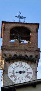 a tall clock tower with a clock on it at Casa Rosina + box per auto 2 bici 1,5km dalle mura in Lucca