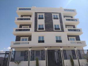 a tall white building with black shutters at White Rose in New cairo