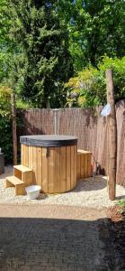 a wooden table and benches in front of a fence at HottuB - Wellnesshuisje - Bos - Oudveluwe in Voorthuizen