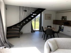 a living room with a staircase and a table at La maison des prés in Guérande +3 photos