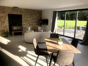 a living room with a wooden table and chairs at La maison des prés in Guérande