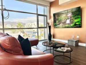ロサンゼルスにあるPenthouse 2 Bedroom with Hollywood Sign View!のソファと大きな窓のあるリビングルーム