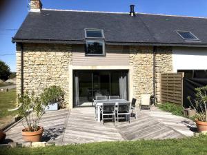 a patio with a table and chairs in front of a building at La maison des prés in Guérande