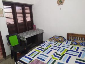 a bedroom with a bed and a chair and a desk at Rest Room, Kanjiramkulam, Trivandrum in Pūvār