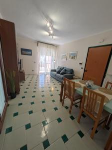a living room with a table and a couch at Orchidea Borghese in Nettuno