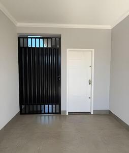 een lege kamer met een witte muur en een deur bij Casa moderna no Jardim Italia in Maringá