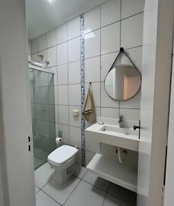 een witte badkamer met een toilet en een wastafel bij Casa moderna no Jardim Italia in Maringá