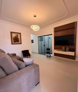 een woonkamer met een bank en een flatscreen-tv bij Casa moderna no Jardim Italia in Maringá +40 foto's