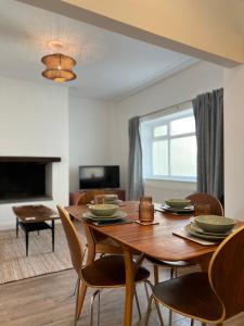 een eetkamer met een houten tafel en stoelen bij The Nest at Amble in Amble