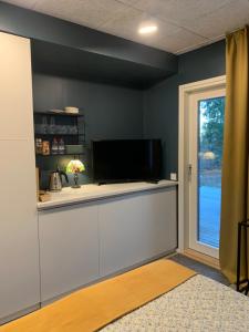 a room with a counter with a tv and a window at Room with sauna and jacuzzi in Siilinjärvi