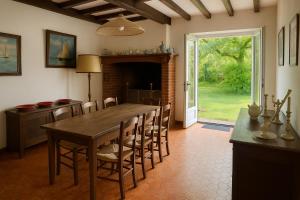 a dining room with a wooden table and chairs at Grande maison familiale avec jardin- 10 pers au coeur du Bearn in Guinarthe-Parenties