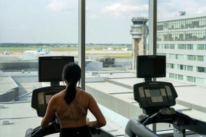 a woman riding on a treadmill at an airport at Marriott Montreal Airport In-Terminal Hotel in Dorval