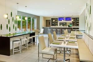 ein Restaurant mit Tischen und Stühlen und einer Bar in der Unterkunft Element Miami International Airport in Miami
