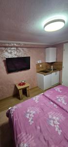 a bedroom with a purple bed and a tv at Sobe Amar in Tuzla
