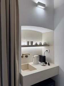 a bathroom with a shelf with a tea pot on it at La Volta in Locorotondo