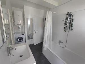 a white bathroom with a sink and a shower at Wohnen bei frau tinz - Studio - Bahnhof- und Zentrumsnähe in Neunkirchen