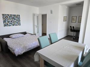 a bedroom with a bed and a table and chairs at Apartmani Magaš in Selce +126 photos