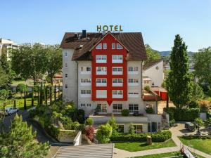 a hotel with a red house on top of it at Kirchers Park & Wellnesshotel Kaiserstuhl in Endingen