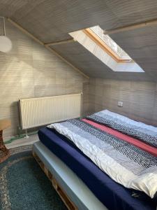 une chambre avec un grand lit avec une lucarne dans l'établissement Cabana Dor De Munte, à Muntele Rece