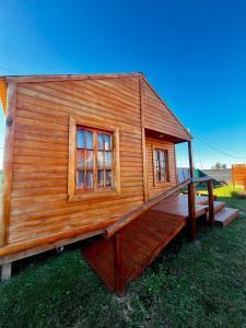 a small log cabin with a window on a deck at Complejo de cabañas Tikuna in Concepción del Uruguay