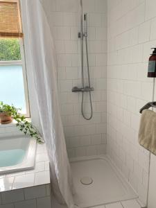 a bathroom with a shower with a tub and a sink at 5 min from the water's edge in Strøby +62 photos
