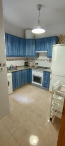 a kitchen with blue cabinets and a white refrigerator at Garrucha Calma y Luz in Garrucha +22 photos