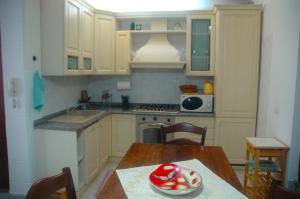 eine Küche mit einem Tisch mit einer Obstschale darauf in der Unterkunft casetta delle stelle in Porto Torres