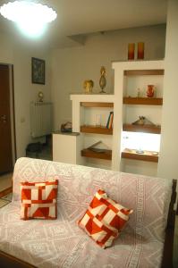 ein Wohnzimmer mit einem weißen Sofa mit orangefarbenen und weißen Kissen in der Unterkunft casetta delle stelle in Porto Torres + 15 Fotos