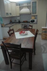 eine Küche mit einem Holztisch mit Stühlen und einem Tisch in der Unterkunft casetta delle stelle in Porto Torres