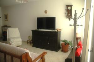 ein Wohnzimmer mit einem Flachbildfernseher auf einem Schrank in der Unterkunft casetta delle stelle in Porto Torres
